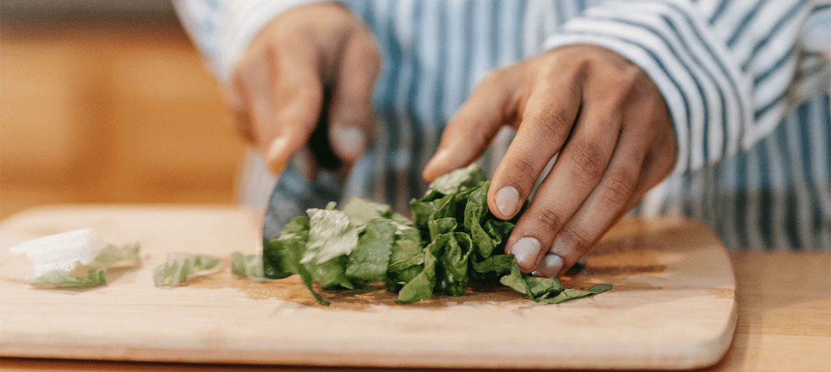 Man cutting herbs on a wooden cutting board: Image: Michael Burrows