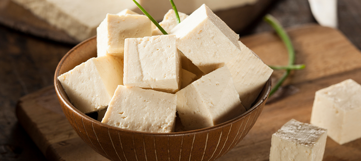 Bowl of cubed tofu on a kitchen counter.