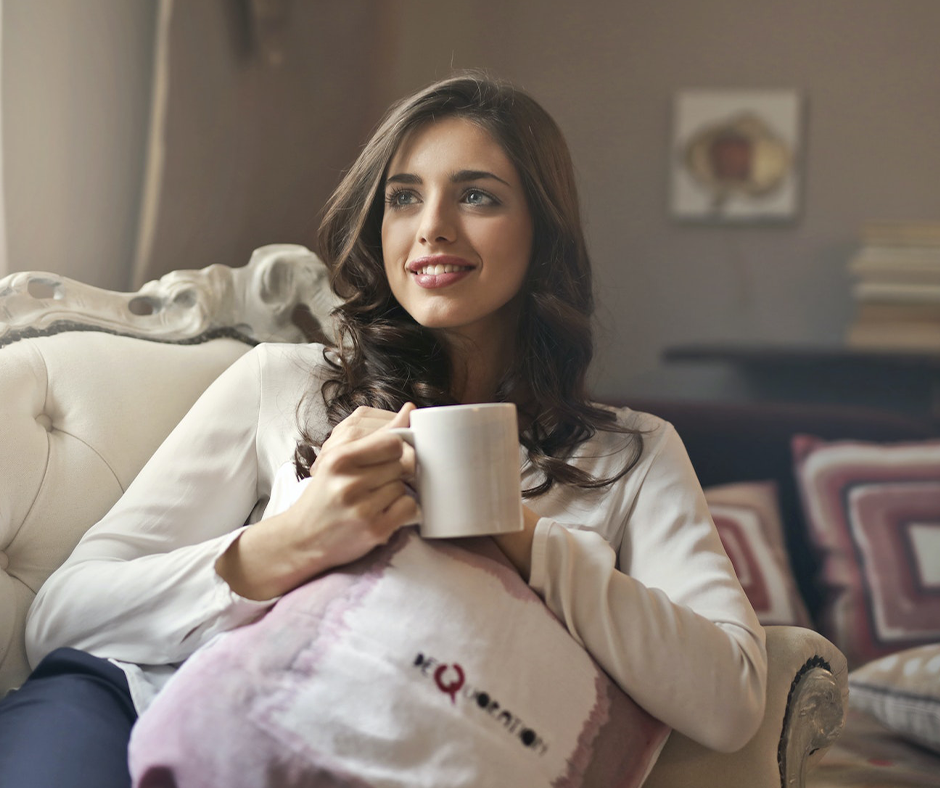 Woman sitting on a couch drinking coffee. Image credit: Andrea Piacquadio